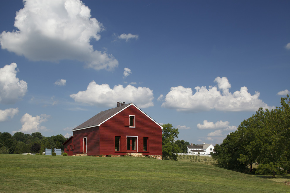 Modelo de fachada roja de estilo de casa de campo grande de dos plantas con revestimiento de madera y tejado de un solo tendido