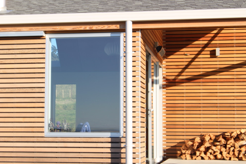 Ejemplo de fachada de casa marrón contemporánea grande de una planta con revestimiento de madera, tejado a dos aguas y tejado de teja de barro