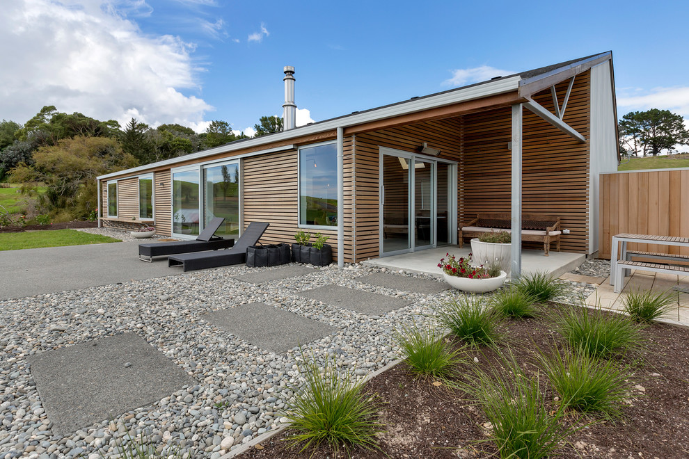 Стильный дизайн: большой, одноэтажный, деревянный, коричневый частный загородный дом в современном стиле с двускатной крышей и черепичной крышей - последний тренд