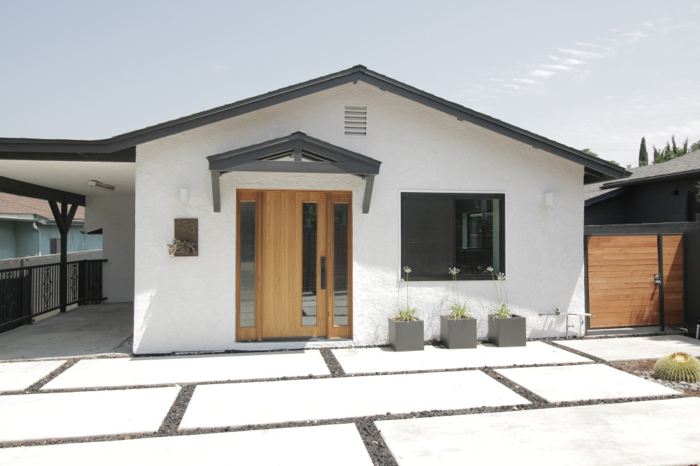 Idées déco pour une façade de maison blanche contemporaine en stuc de taille moyenne et de plain-pied avec un toit à deux pans et un toit en shingle.