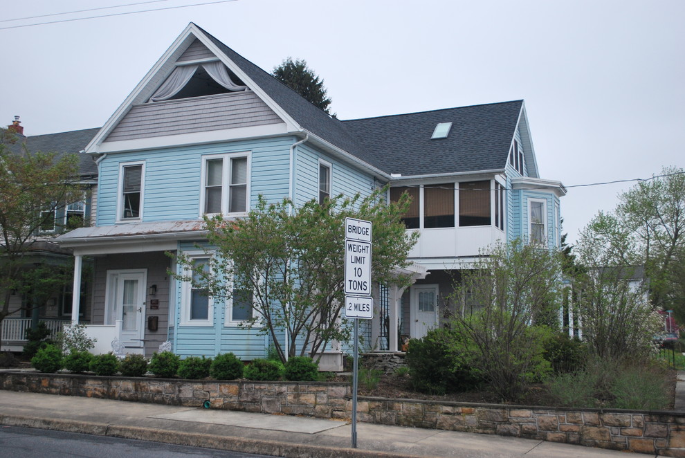Photo of a large victorian front flat in Philadelphia with three floors, vinyl cladding, a pitched roof and a shingle roof.