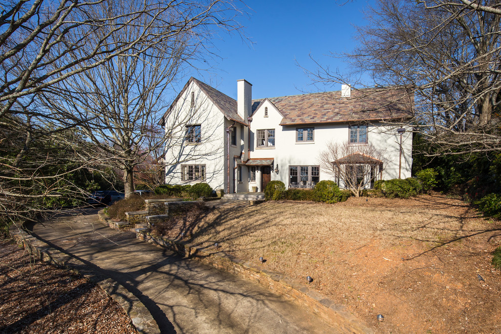 Inspiration for a large country gray two-story stucco house exterior remodel in Birmingham with a hip roof and a shingle roof