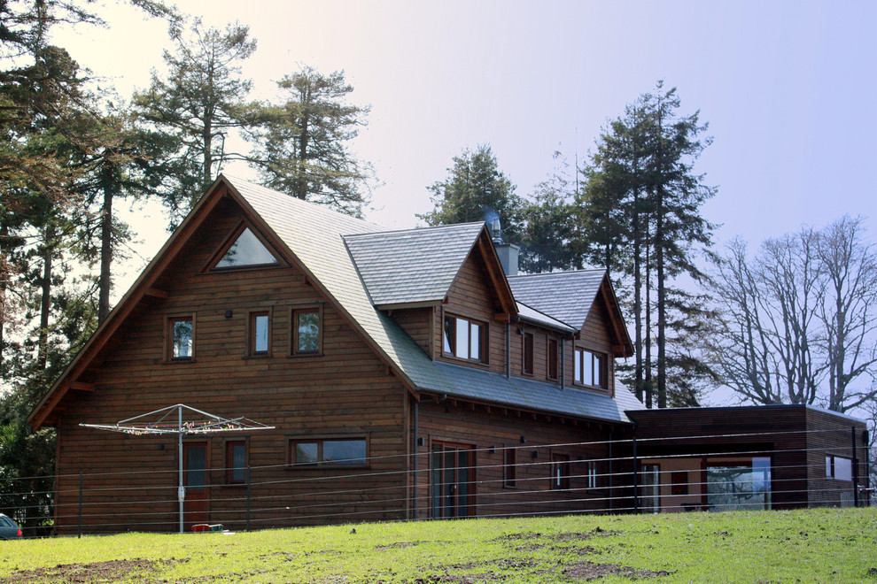 Пример оригинального дизайна: большой, двухэтажный, деревянный, коричневый дом в стиле модернизм