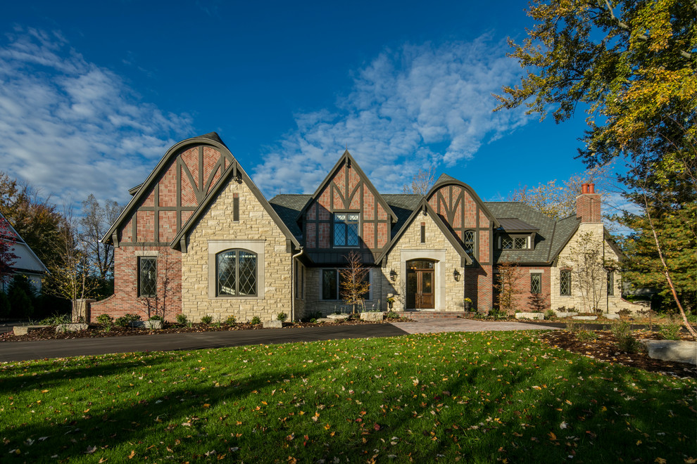 Photo of a large and red classic two floor brick house exterior in Grand Rapids with a half-hip roof.