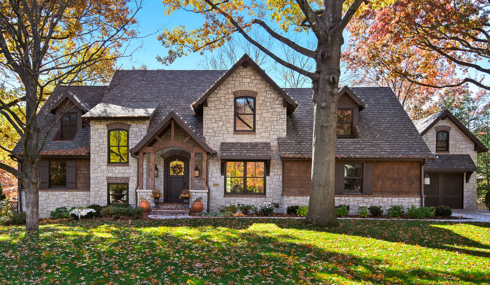 Imagen de fachada de casa marrón de estilo americano de dos plantas con revestimientos combinados y tejado a cuatro aguas