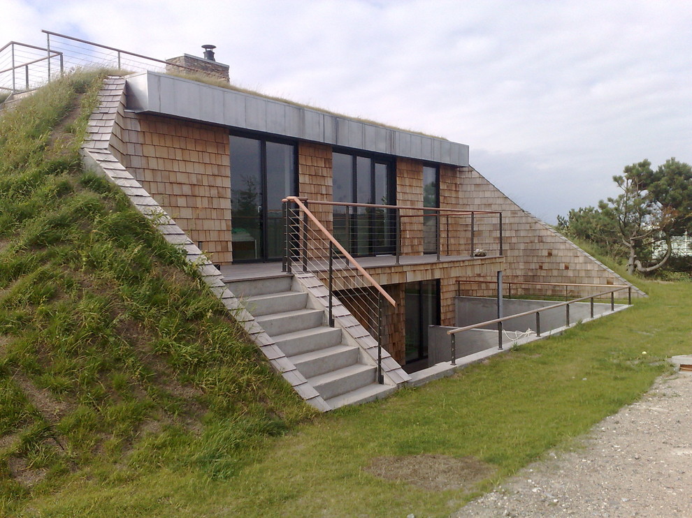 Пример оригинального дизайна: двухэтажный, кирпичный, бежевый частный загородный дом в скандинавском стиле с плоской крышей и зеленой крышей
