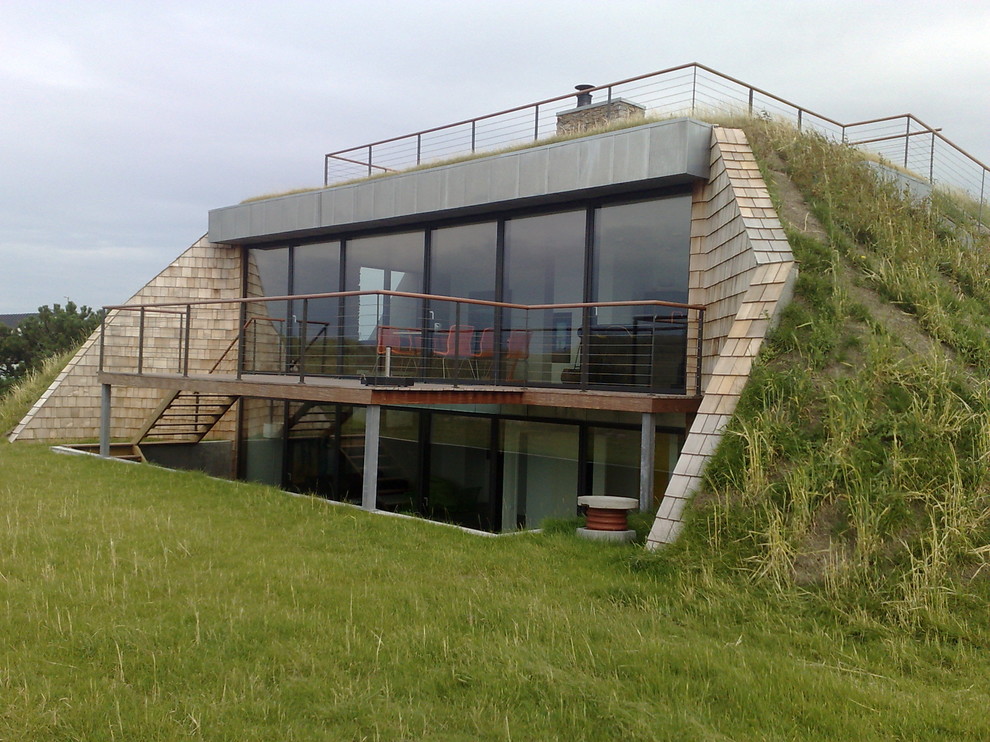 Idéer för ett mellanstort nordiskt beige hus, med två våningar, tegel, platt tak och levande tak