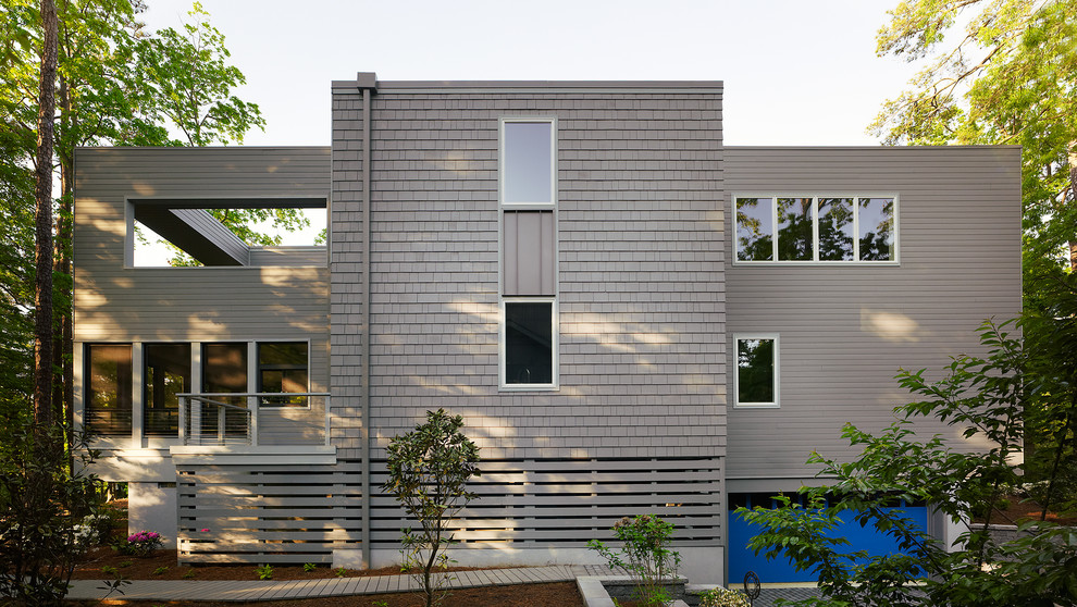 Aménagement d'une très grande façade de maison grise contemporaine en bois à un étage avec un toit plat.