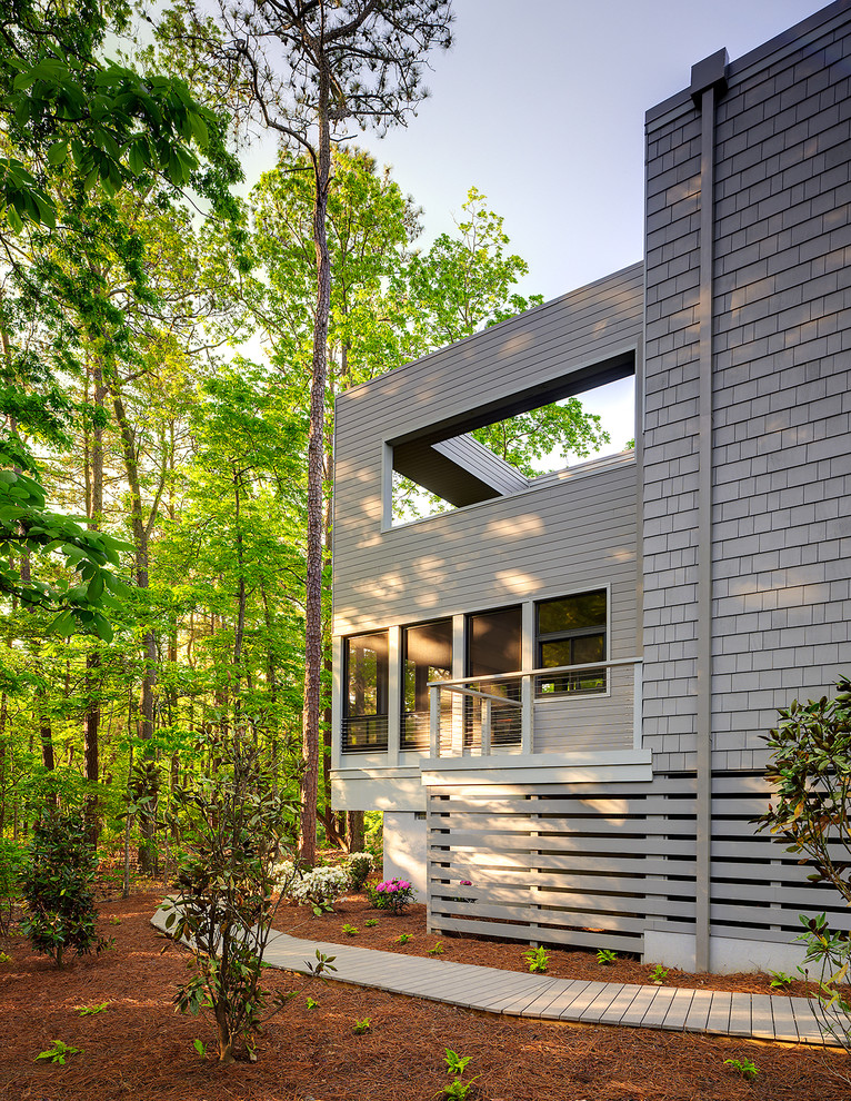 Ispirazione per la facciata di una casa ampia grigia moderna a due piani con rivestimento in legno e tetto piano