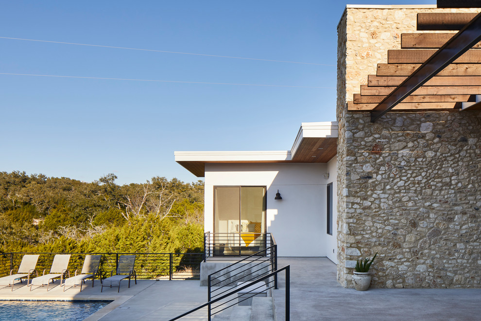 Diseño de fachada de casa beige moderna extra grande de una planta con tejado plano, tejado de varios materiales y revestimientos combinados