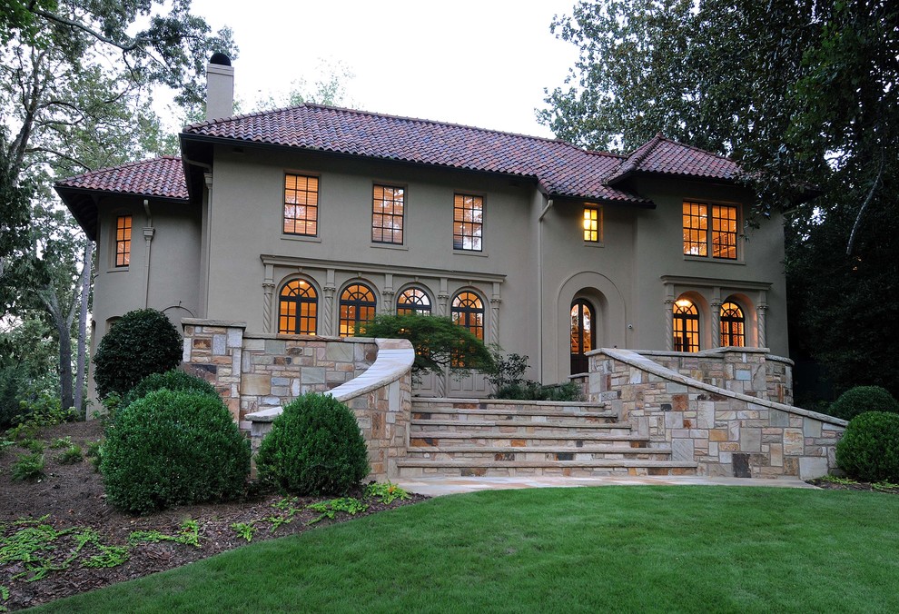 На фото: большой, двухэтажный, коричневый частный загородный дом в средиземноморском стиле с облицовкой из цементной штукатурки, двускатной крышей и черепичной крышей