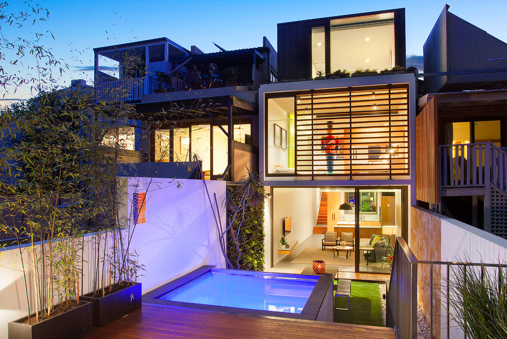Стильный дизайн: трехэтажный, белый дом в стиле модернизм с облицовкой из бетона и плоской крышей - последний тренд
