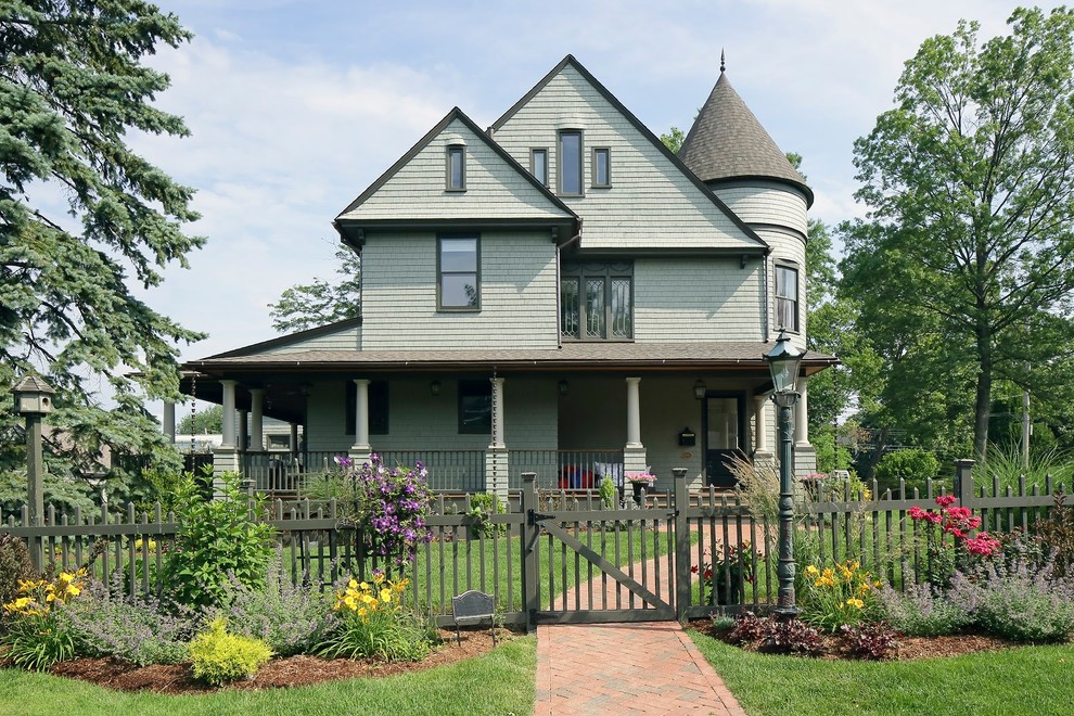 Свежая идея для дизайна: двухэтажный, зеленый дом в викторианском стиле с двускатной крышей - отличное фото интерьера