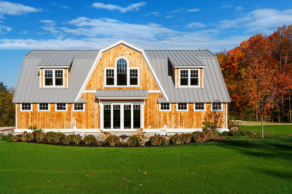 Diseño de fachada de casa beige de estilo de casa de campo de tamaño medio de dos plantas con revestimiento de madera, tejado a doble faldón y tejado de metal