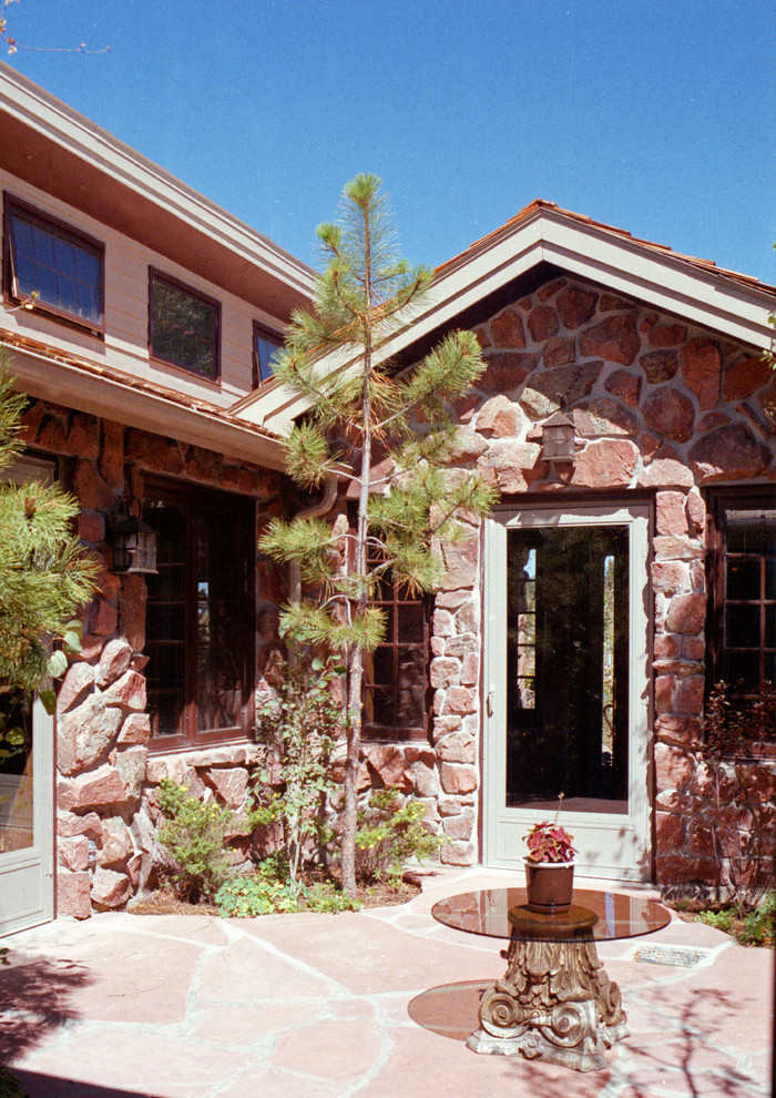 Imagen de fachada rústica grande de dos plantas con revestimiento de piedra
