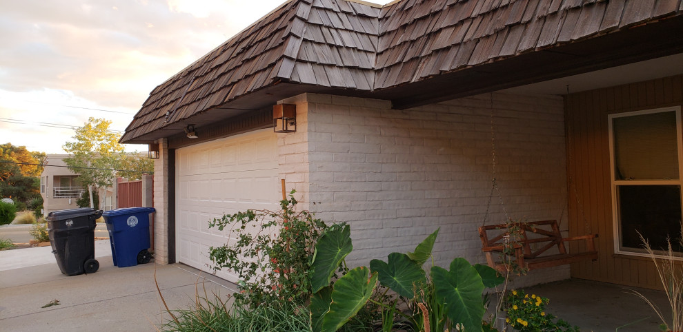 Inspiration pour une façade de maison marron traditionnelle en stuc de taille moyenne et de plain-pied avec un toit plat.