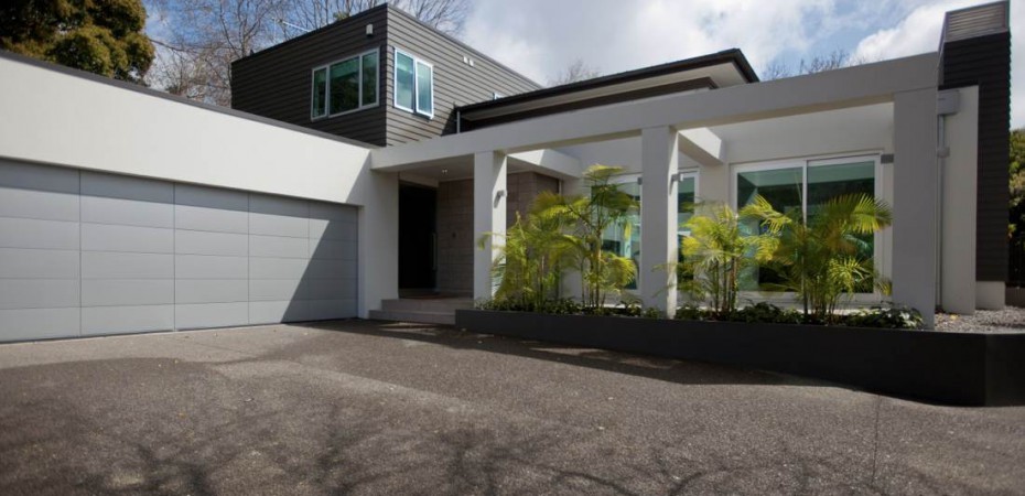 Diseño de fachada de casa multicolor actual grande de dos plantas con revestimientos combinados y tejado plano