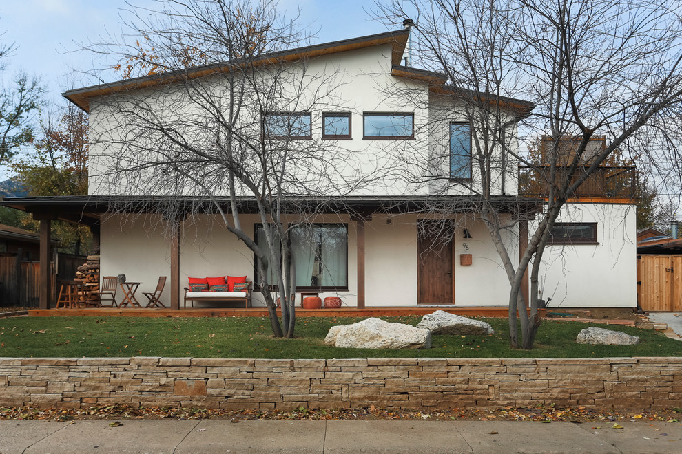 Imagen de fachada de casa beige tradicional renovada de tamaño medio de dos plantas con revestimiento de estuco, tejado plano y techo verde