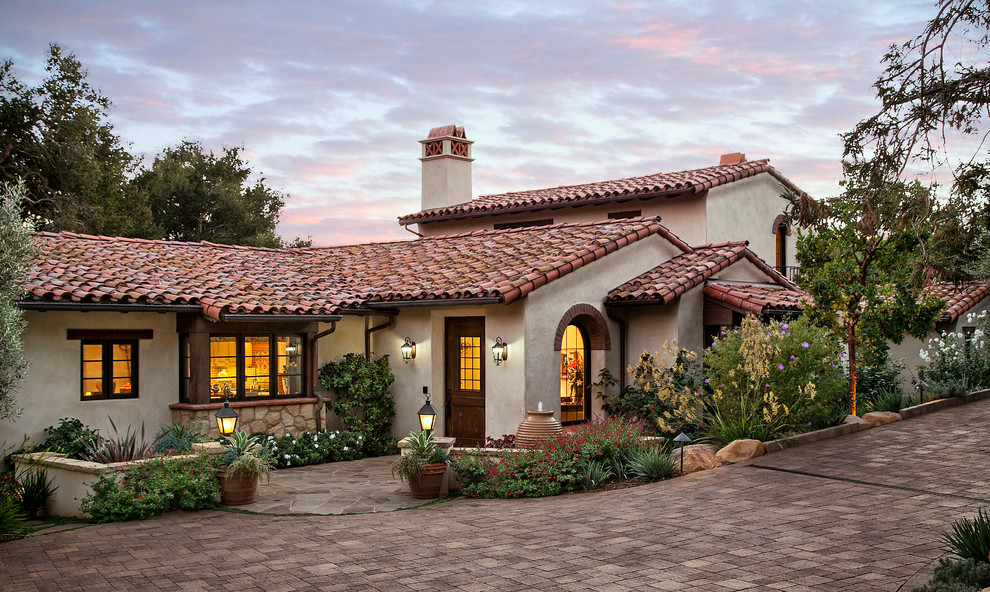 This is an example of a beige mediterranean two floor house exterior in Santa Barbara.