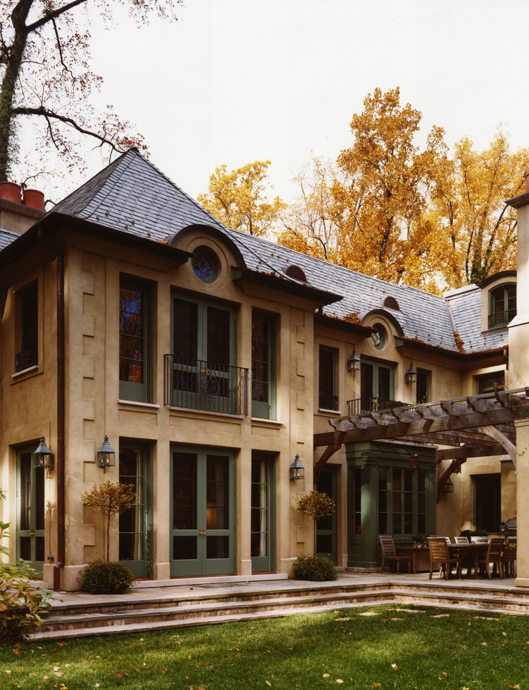 Идея дизайна: двухэтажный, бежевый дом в классическом стиле с облицовкой из цементной штукатурки