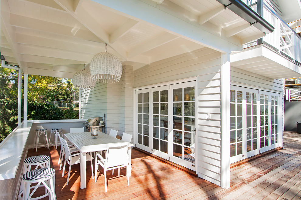 This is an example of a large and white contemporary two floor house exterior in Brisbane with wood cladding.