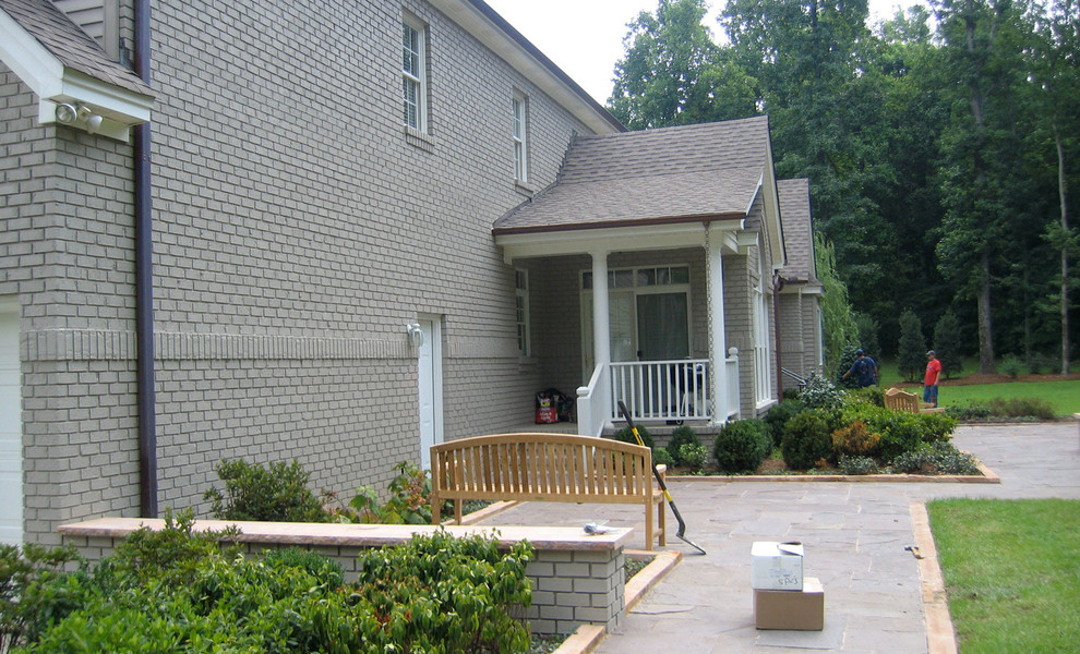 Cette photo montre une grande façade de maison grise tendance en brique à un étage.