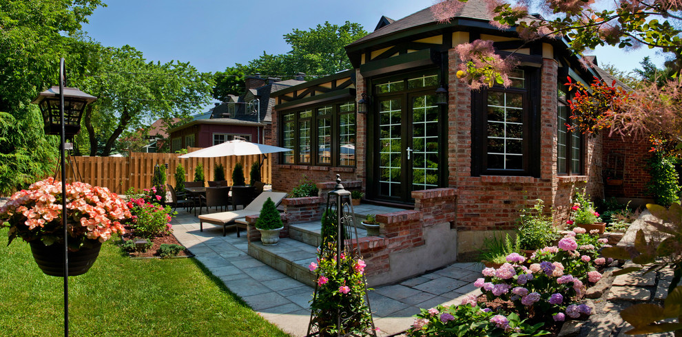 Example of a country brown brick exterior home design in Other