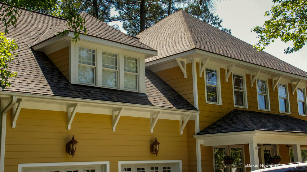 Example of a mid-sized arts and crafts yellow two-story concrete fiberboard gable roof design in Charlotte