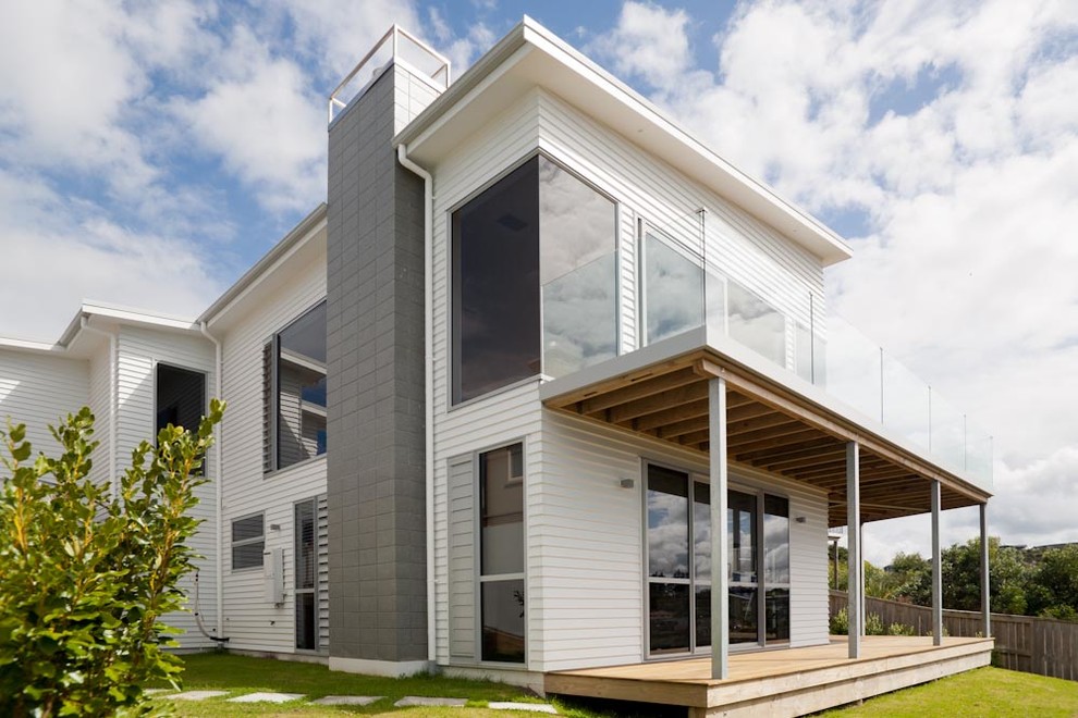 Inspiration for a medium sized and white contemporary bungalow detached house in Auckland with concrete fibreboard cladding, a flat roof and a metal roof.