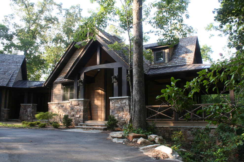 Traditional house exterior in Other with stone cladding and a shingle roof.
