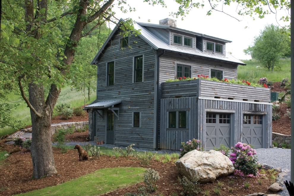Immagine della facciata di una casa grigia country a due piani con rivestimento in legno e tetto a padiglione