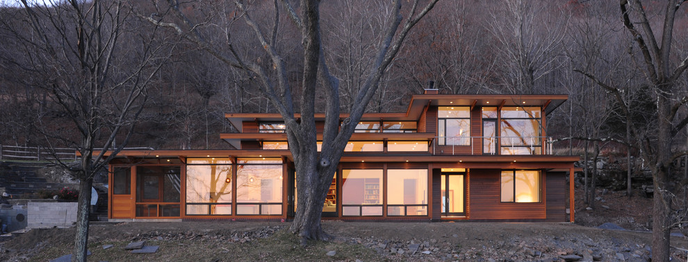 Foto de fachada de casa marrón actual de dos plantas con revestimiento de madera y tejado plano