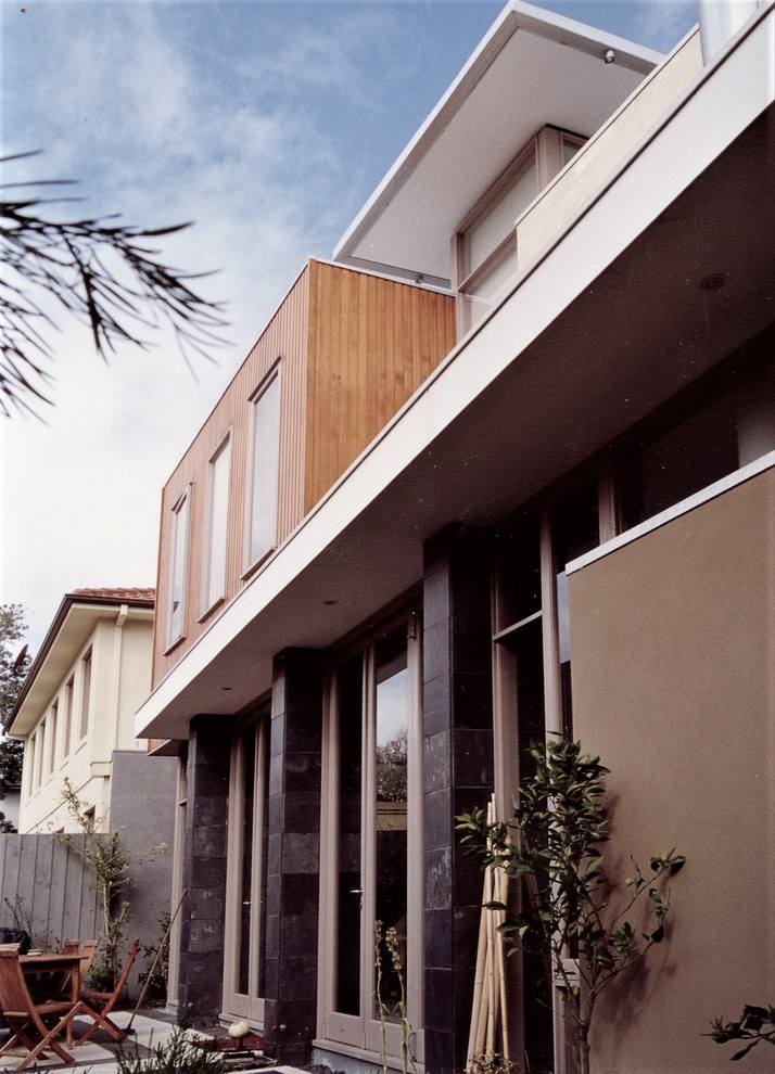 Idées déco pour une façade de maison multicolore contemporaine de taille moyenne et à un étage avec un revêtement mixte et un toit plat.
