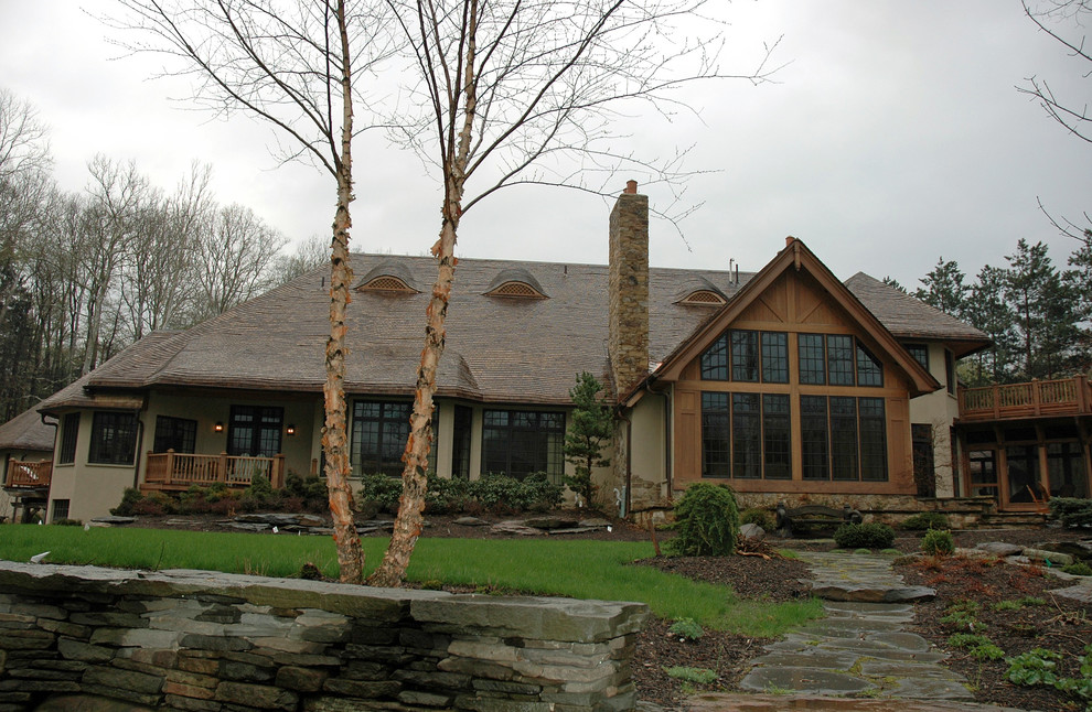 Inspiration for a large and beige rustic two floor render house exterior in Cleveland.