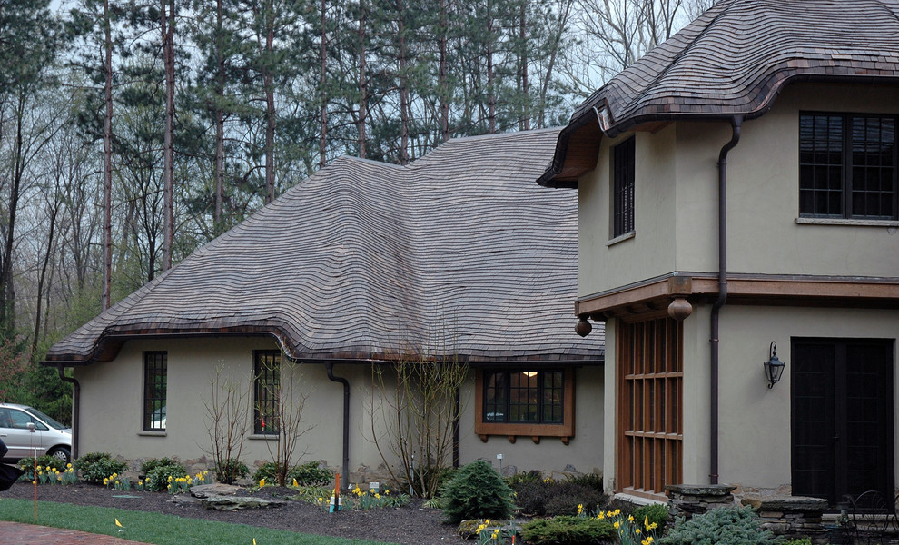 Example of a large mountain style beige two-story stucco exterior home design in Cleveland
