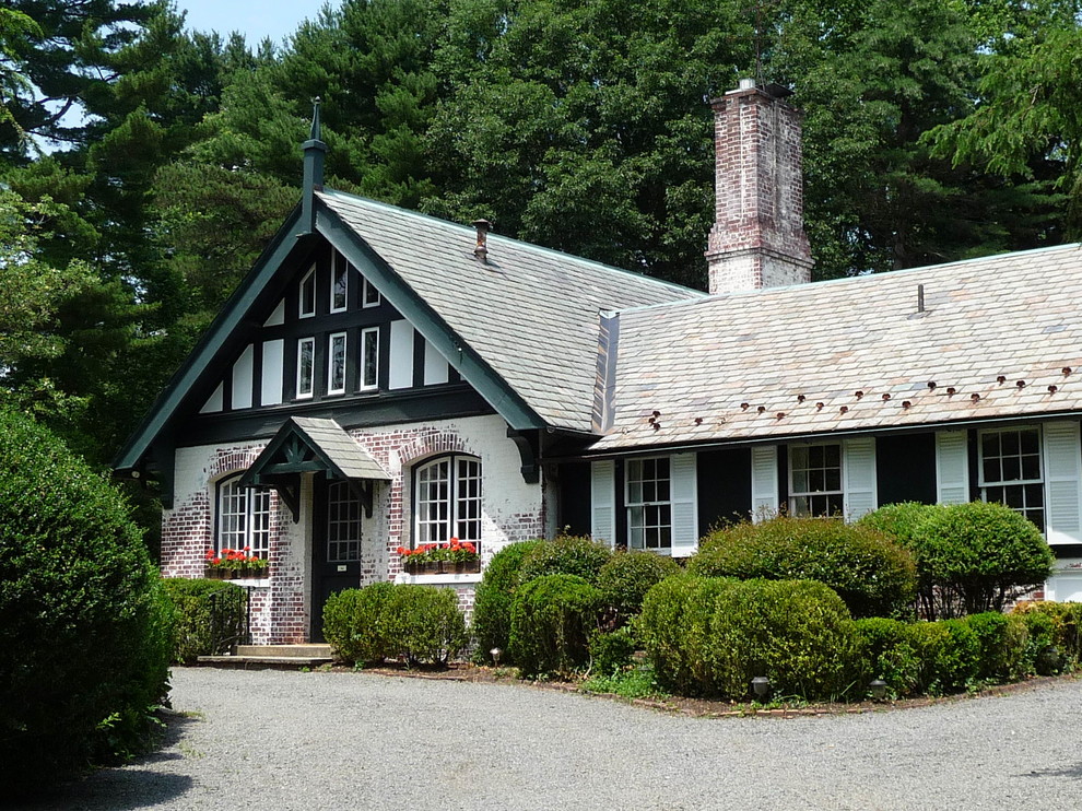 Ispirazione per la facciata di una casa verde country a due piani di medie dimensioni con rivestimento in mattoni e tetto a capanna