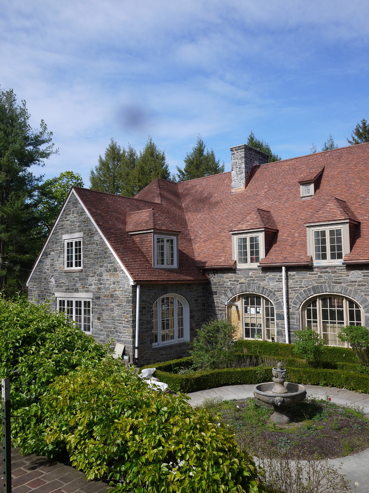 На фото: большой, трехэтажный дом в классическом стиле с облицовкой из камня, двускатной крышей и крышей из гибкой черепицы