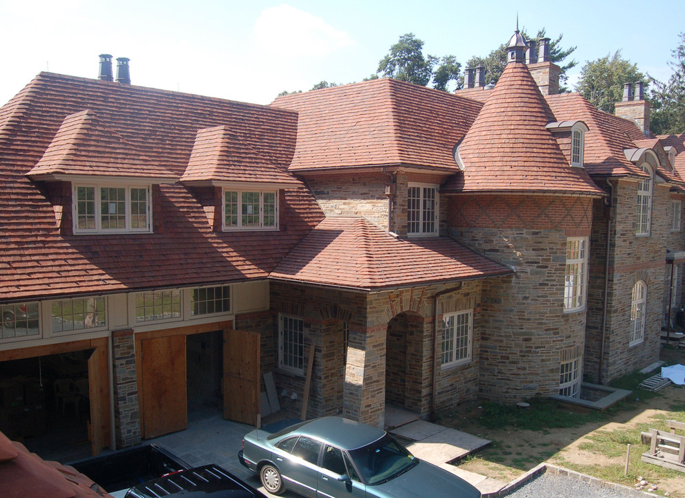 Cette photo montre une façade de maison tendance en pierre à un étage avec un toit à quatre pans.