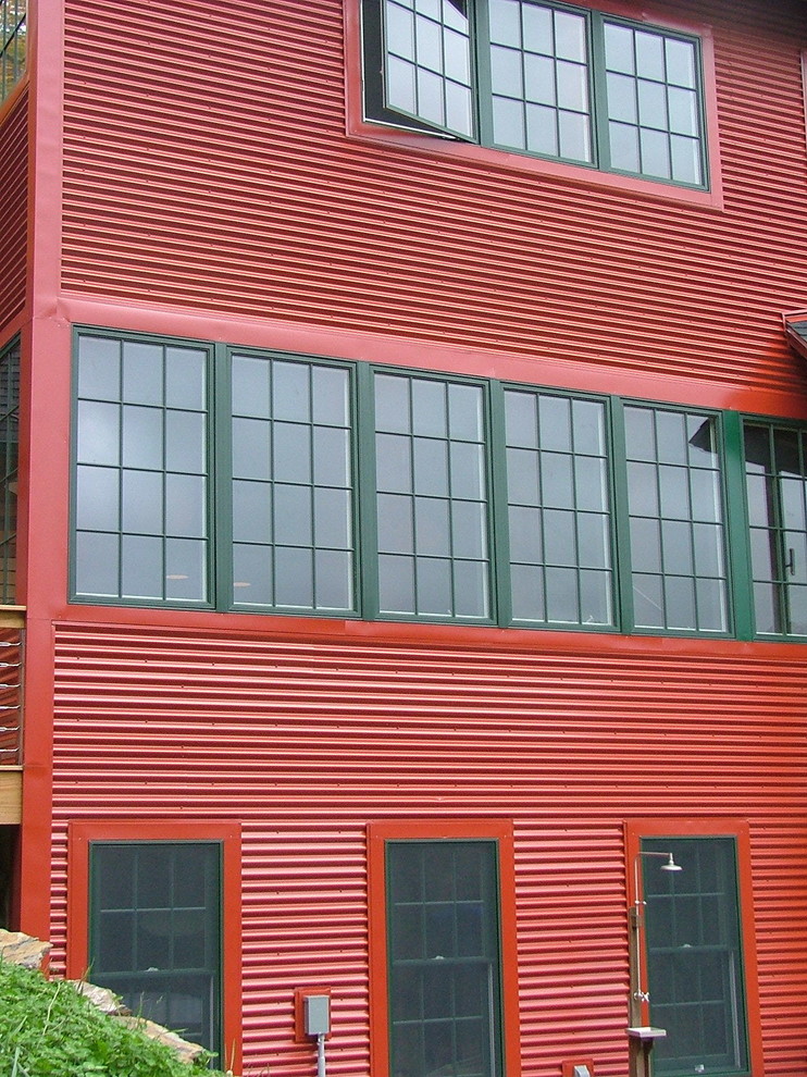 Idées déco pour une façade de maison métallique et rouge contemporaine.