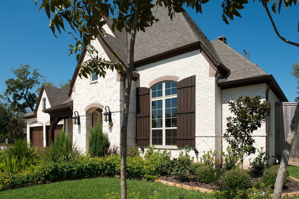 Example of a classic beige two-story brick exterior home design in Dallas