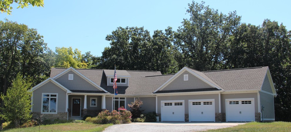 Ejemplo de fachada de casa gris de estilo americano de una planta con revestimiento de madera, tejado a dos aguas y tejado de teja de madera