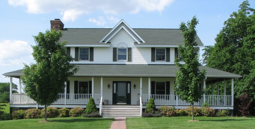 Einstöckiges Country Einfamilienhaus mit Vinylfassade, weißer Fassadenfarbe, Satteldach und Schindeldach in Sonstige