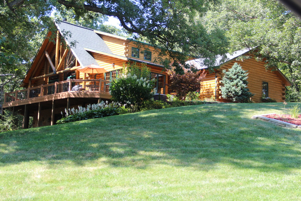Imagen de fachada de casa multicolor rural de una planta con revestimiento de madera, tejado a dos aguas y tejado de teja de madera