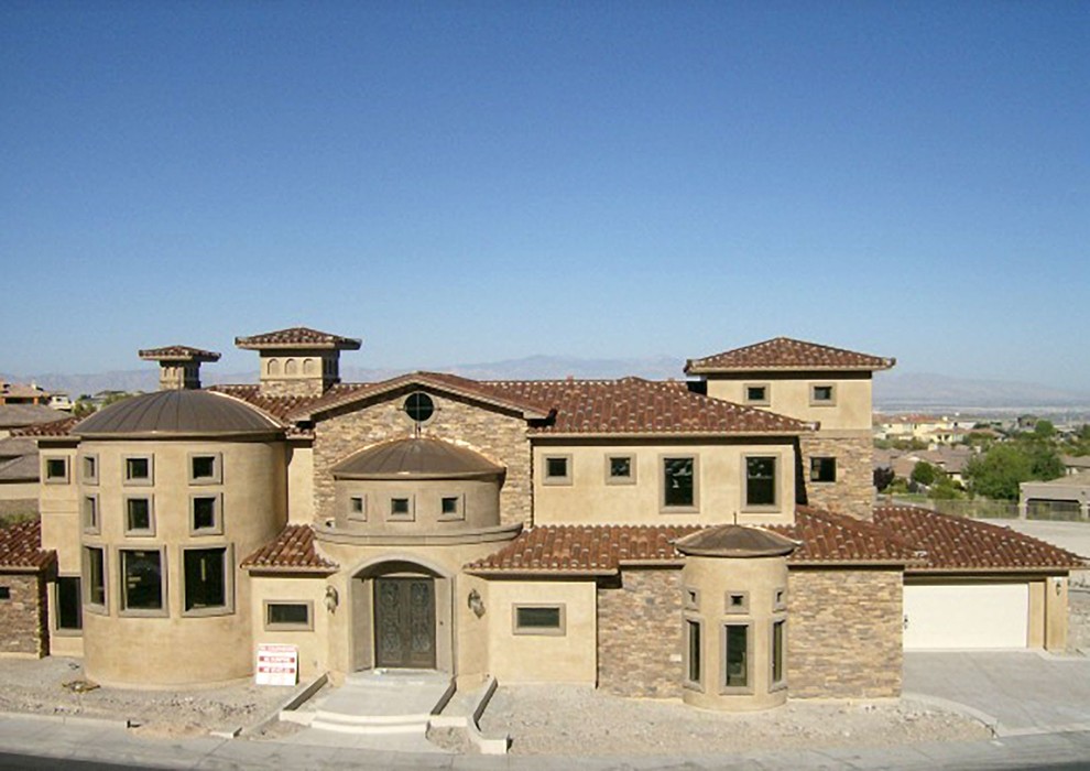 Idées déco pour une grande façade de maison beige méditerranéenne à un étage avec un revêtement mixte, un toit à quatre pans et un toit mixte.