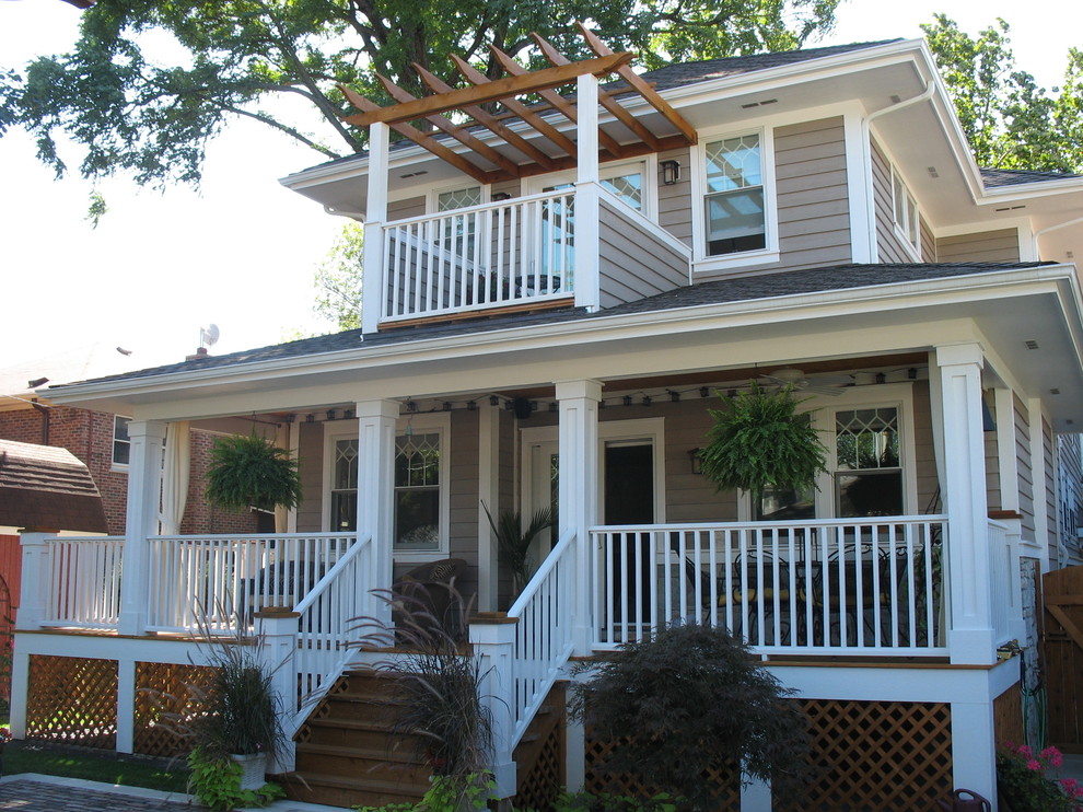 Exemple d'une façade de maison beige craftsman en bois de taille moyenne et à un étage avec un toit à quatre pans.