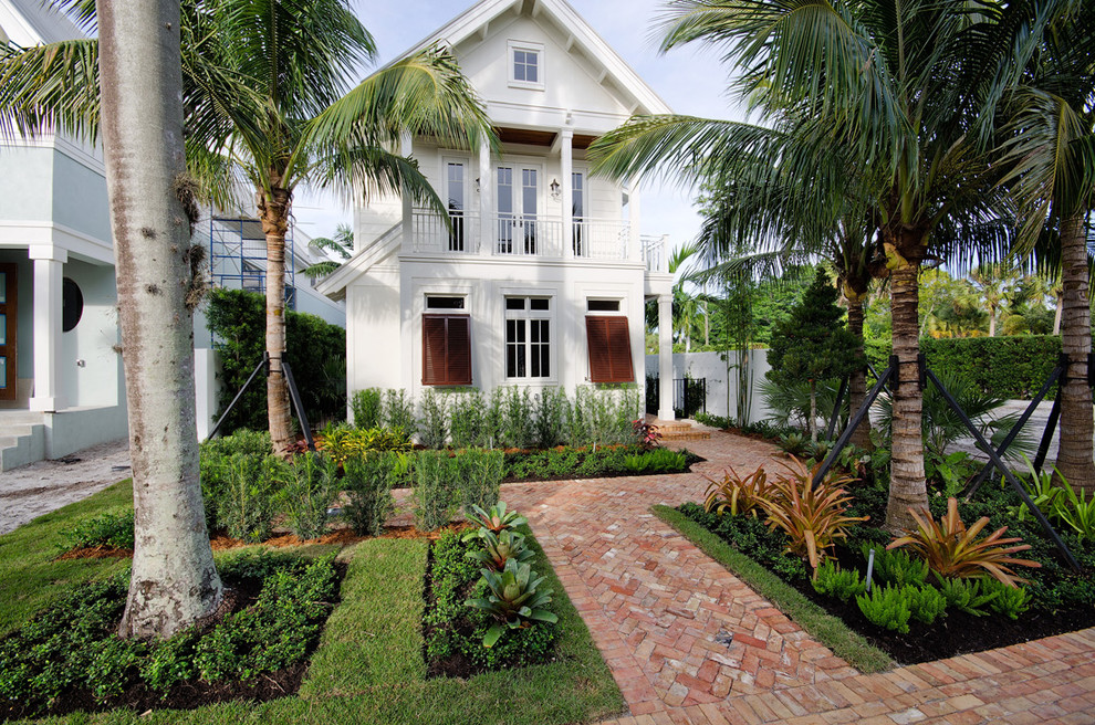 Immagine della villa bianca tropicale a due piani di medie dimensioni con tetto a capanna e copertura in metallo o lamiera
