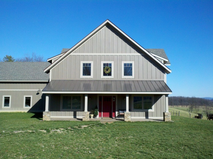 Esempio della facciata di una casa grigia country a due piani con rivestimento in legno