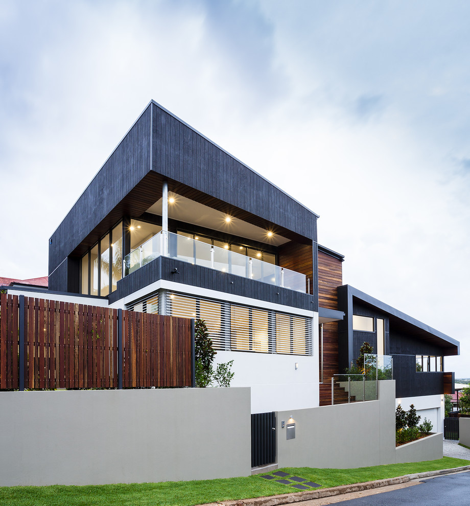 Ejemplo de fachada de casa gris contemporánea grande a niveles con revestimientos combinados y tejado plano