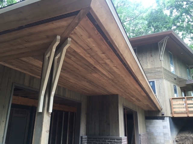 Modelo de fachada de casa marrón rústica de tamaño medio de dos plantas con revestimiento de madera, tejado a dos aguas y tejado de teja de barro