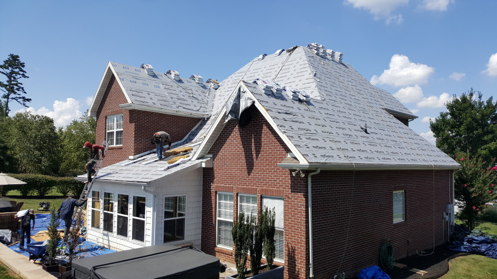 Idée de décoration pour une grande façade de maison tradition de plain-pied avec un toit papillon et un toit en métal.